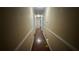 Long hallway with wood floor, base molding, and access to rooms at 1833 Stephenson Rd, Lithonia, GA 30058