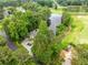 Stunning aerial view of the home featuring lush landscaping, circular driveway, and adjacent golf course and pond at 550 Atlanta Country Club Se Dr, Marietta, GA 30067