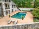 The exterior back of the home featuring a backyard pool, lounge chairs, and manicured shrubs at 550 Atlanta Country Club Se Dr, Marietta, GA 30067