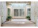 Bright bathroom with white tile, soaking tub with granite surround, and plantation shutters for privacy at 550 Atlanta Country Club Se Dr, Marietta, GA 30067