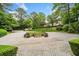 Circular driveway with manicured landscaping, leading to an elegant home in a lush setting at 550 Atlanta Country Club Se Dr, Marietta, GA 30067