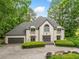 Elegant front exterior of the home featuring a gray roof, manicured lawn, and double doors at 550 Atlanta Country Club Se Dr, Marietta, GA 30067