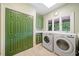 Functional laundry room with green cabinets, a utility sink, and modern washer and dryer units at 550 Atlanta Country Club Se Dr, Marietta, GA 30067