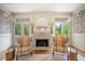 Elegant living room featuring a detailed fireplace with an ornate mirror and decorative chairs at 550 Atlanta Country Club Se Dr, Marietta, GA 30067