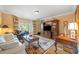 Comfortable living room with a bay window, hardwood floors, a large entertainment center, and classic decor at 550 Atlanta Country Club Se Dr, Marietta, GA 30067
