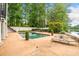 Outdoor pool area overlooking a lush backyard and tranquil lake, perfect for relaxation and recreation at 550 Atlanta Country Club Se Dr, Marietta, GA 30067