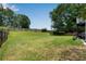 Expansive backyard featuring a large grassy area, mature trees, and a privacy fence at 607 Lexington Way, Woodstock, GA 30189