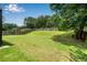Large backyard with a beautiful lawn, mature trees, and a well-maintained wooden fence at 607 Lexington Way, Woodstock, GA 30189