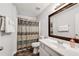 Bathroom features a shower with curtain, sink and dark wood mirror at 607 Lexington Way, Woodstock, GA 30189