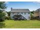 Two story home with deck overlooking large backyard, patio, and well-manicured lawn at 607 Lexington Way, Woodstock, GA 30189