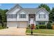 Charming two-story home with a two-car garage, stone accents, and a well-maintained lawn at 607 Lexington Way, Woodstock, GA 30189