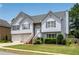 Charming two-story home with a two-car garage, stone accents, and a well-maintained lawn at 607 Lexington Way, Woodstock, GA 30189
