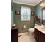 Cozy bathroom with green paint, commode and a vanity with sink at 21 Picketts Ridge Ln, Acworth, GA 30101
