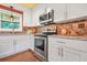 Modern kitchen featuring white cabinetry, stainless steel appliances, and granite countertops at 3839 Brookcrest Cir, Decatur, GA 30032