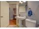 Bathroom with a white pedestal sink, toilet and a view into the next room at 410 Fitzgerald Ln, Fayetteville, GA 30215