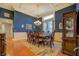 Elegant dining room with dark blue walls, white trim, hardwood floors, and a decorative chandelier at 410 Fitzgerald Ln, Fayetteville, GA 30215