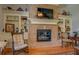 Cozy brick fireplace with a TV, built-in bookshelves, and hardwood floors at 410 Fitzgerald Ln, Fayetteville, GA 30215