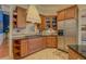 Kitchen area featuring a range hood and stainless steel appliances with wooden cabinets and tiled backsplash at 410 Fitzgerald Ln, Fayetteville, GA 30215