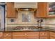 Close up of gas stovetop and backsplash in kitchen featuring granite countertops and stainless steel appliance at 410 Fitzgerald Ln, Fayetteville, GA 30215