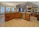 Kitchen island with dark countertops and wood cabinets opens to the breakfast area and living room at 410 Fitzgerald Ln, Fayetteville, GA 30215