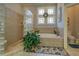 Luxurious main bathroom featuring a garden tub, glass block accents, and tiled walls at 410 Fitzgerald Ln, Fayetteville, GA 30215