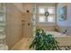Luxurious bathroom featuring a garden tub, glass block accents, and tiled walls at 410 Fitzgerald Ln, Fayetteville, GA 30215
