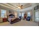 Spacious main bedroom with a tray ceiling, natural light, and carpet flooring at 410 Fitzgerald Ln, Fayetteville, GA 30215