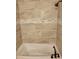 Elegant bathtub with decorative tile and a shower head, creating a spa-like experience in the bathroom at 1167 Oakland Sw Dr, Atlanta, GA 30310