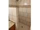 Shower boasts beige tile with a granite countertop vanity in bathroom at 1167 Oakland Sw Dr, Atlanta, GA 30310