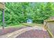 Landscaped backyard with decorative stone path and charming playhouse at 1575 Petal Nw Pt, Kennesaw, GA 30152