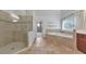 Elegant bathroom featuring a glass-enclosed shower, soaking tub, and tile accents at 1575 Petal Nw Pt, Kennesaw, GA 30152