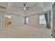 Spacious bedroom features a tray ceiling with fan, carpet floors, and access to bathroom at 1575 Petal Nw Pt, Kennesaw, GA 30152