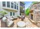 Luxury backyard patio with stone fireplace, outdoor furniture, and lush landscaping at 1575 Petal Nw Pt, Kennesaw, GA 30152