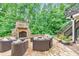 Lush backyard featuring a stone fireplace, a stone patio, and outdoor furniture at 1575 Petal Nw Pt, Kennesaw, GA 30152