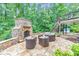 Outdoor patio featuring a stone fireplace, comfortable seating, and mature trees at 1575 Petal Nw Pt, Kennesaw, GA 30152