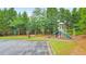 Community playground featuring a slide, swings, and monkey bars, surrounded by lush trees at 1575 Petal Nw Pt, Kennesaw, GA 30152
