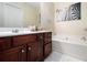 Charming bathroom with dark wood cabinets, a soaking tub, and a stylish zebra print artwork at 2555 Flat Shoals Rd # 1405, Atlanta, GA 30349