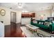 Inviting living room featuring hardwood floors, a green sofa, and an open layout connecting to the kitchen area at 2555 Flat Shoals Rd # 1405, Atlanta, GA 30349