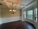 Elegant dining room boasts coffered ceilings, dark wood floors, and a bay window at 381 Plymstock Dr, Mcdonough, GA 30253