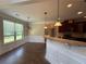 Open-concept kitchen with granite countertops, dark wood cabinets, and pendant lighting at 381 Plymstock Dr, Mcdonough, GA 30253
