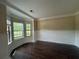 Bright living room features dark wood floors, crown molding, and a large bay window at 381 Plymstock Dr, Mcdonough, GA 30253