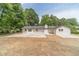 Charming backyard with a concrete patio, freshly laid straw, and surrounding mature trees at 703 Alvis Ln, Norcross, GA 30093