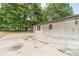 Concrete patio area, rear entrance, and yard surrounded by lush greenery at 703 Alvis Ln, Norcross, GA 30093