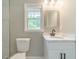 This bathroom features white vanity, mirror, and a window with natural light at 703 Alvis Ln, Norcross, GA 30093