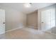 This bedroom features carpet, neutral paint, and access to other rooms at 703 Alvis Ln, Norcross, GA 30093