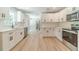 Bright, renovated kitchen featuring white cabinets, stainless steel appliances, and modern fixtures at 703 Alvis Ln, Norcross, GA 30093