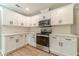 Renovated kitchen boasts white cabinetry, stainless steel appliances, and stylish countertop at 703 Alvis Ln, Norcross, GA 30093