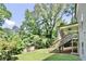 Expansive backyard with lush green lawn, mature trees, and a charming elevated deck with stairs at 1300 Winfair Ne Ln, Brookhaven, GA 30329