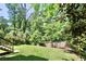 Lush backyard featuring a well-maintained lawn surrounded by mature trees and a classic wooden fence at 1300 Winfair Ne Ln, Brookhaven, GA 30329