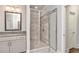 Bathroom featuring a granite vanity, walk-in shower with glass door, and neutral tile at 1300 Winfair Ne Ln, Brookhaven, GA 30329